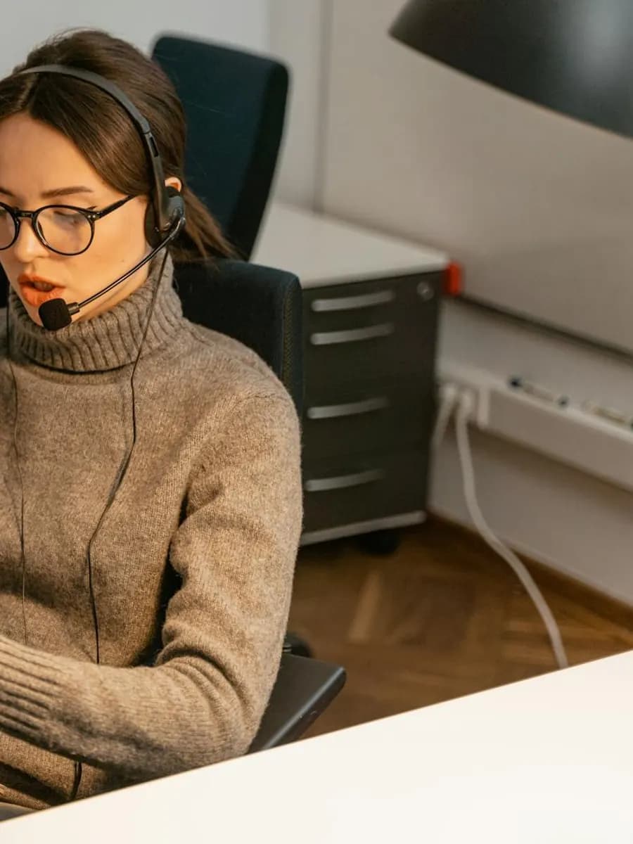Customer support specialist working at a desk with a laptop and headset