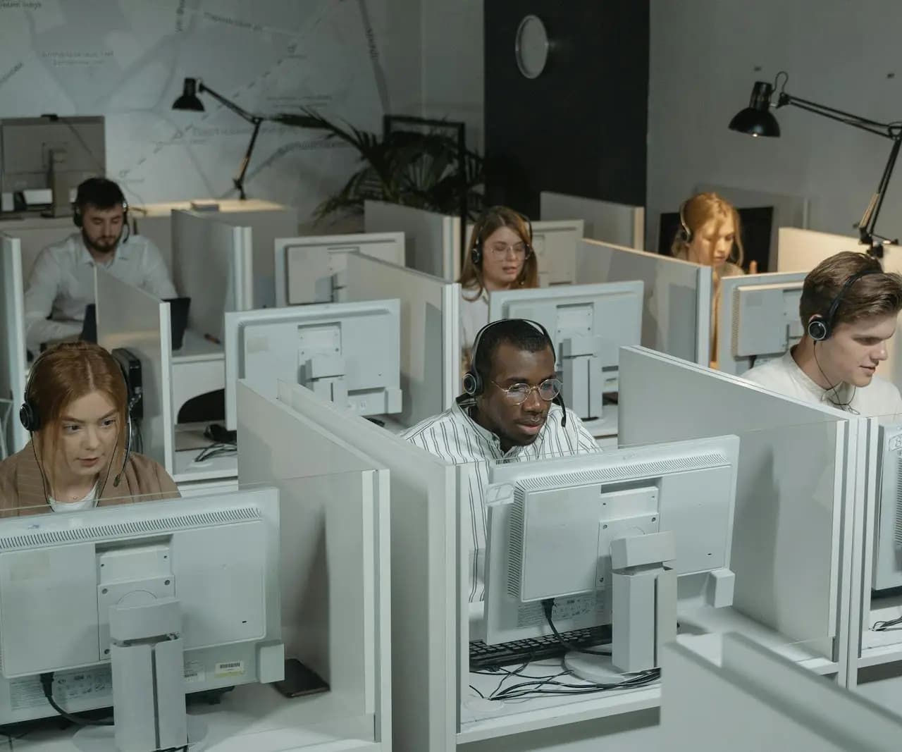 Customer support team using headsets and computers in an office