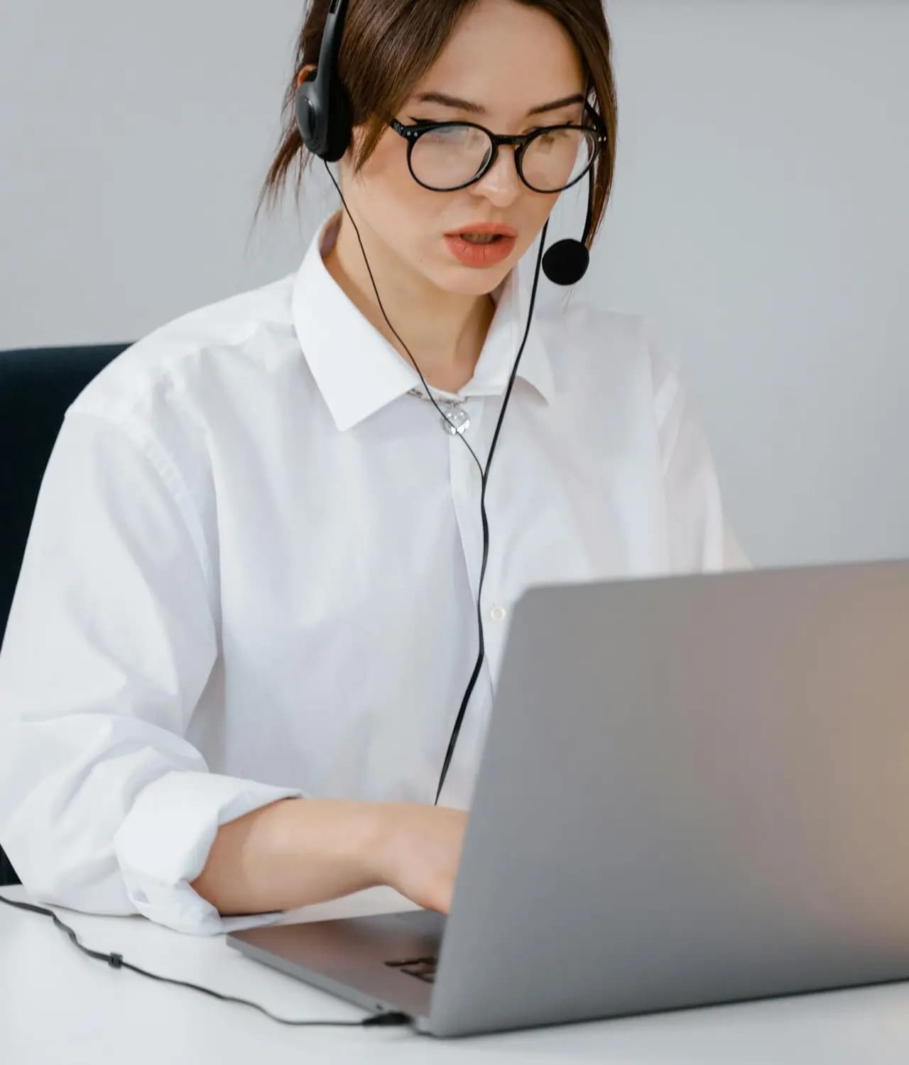 Telemarketing agent using a headset while working on a laptop