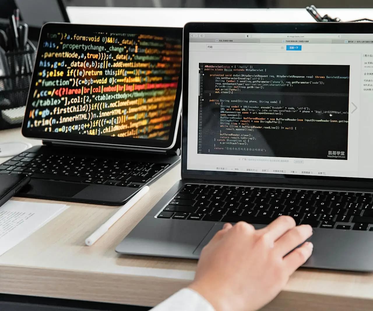 Developer writing code on a laptop in an office workspace